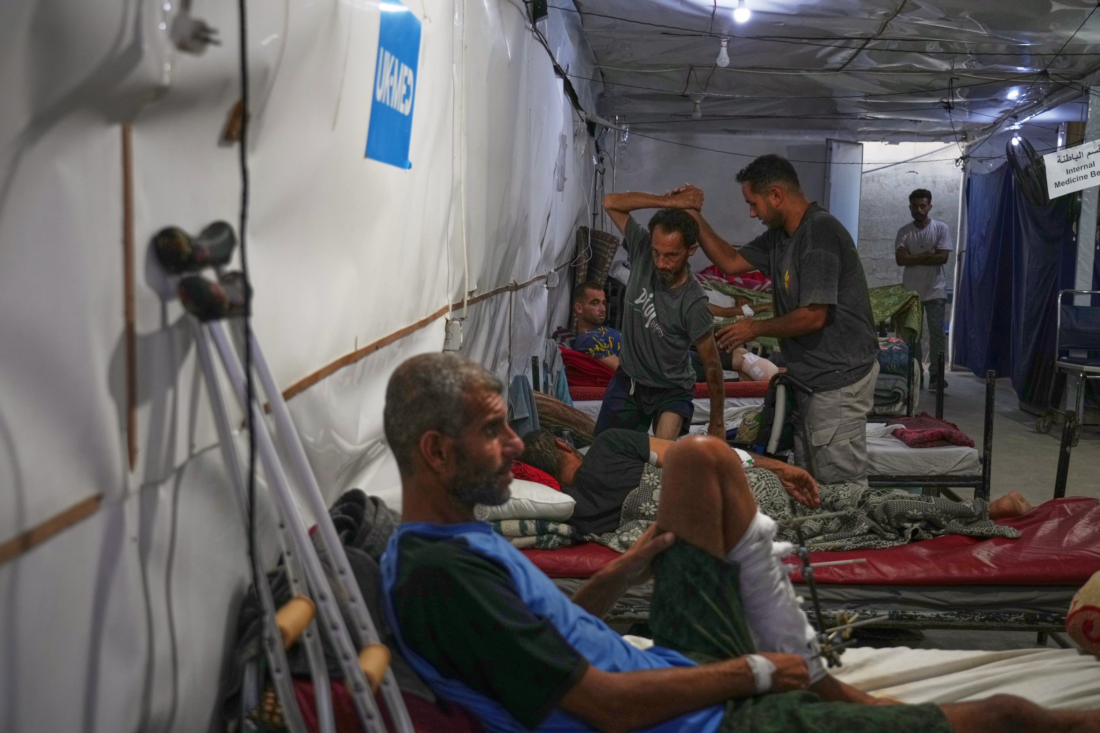 Dr. Paul Ransom of the British humanitarian medical NGO UK-Med, assisted by local medical staff, treats patients at a field hospital in Muwasi, near Khan Younis. (AP)