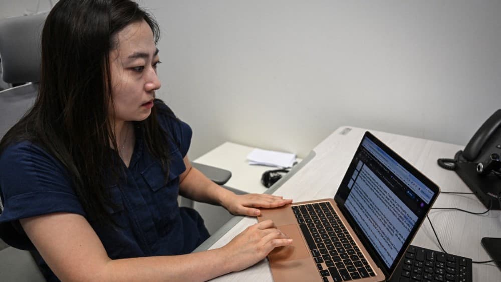 This photo taken on July 17, 2026 shows South Korean advocate Baek Song-yi showing her trial evidence on her laptop during an interview with AFP in Seoul (Photo by JADE GAO / AFP)