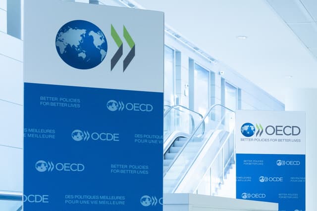 This photograph, taken on September 22, 2025, shows the logo of the Organization for Economic Cooperation and Development (OECD) displayed on banners at the OECD headquarters in Paris. (AFP)
