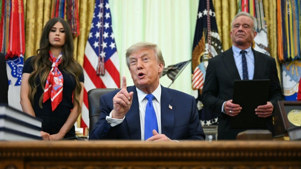 US President Donald Trump speaks after signing an executive order calling for more research and flexibility on vaccines, alongside US Secretary of Health and Human Services Robert F. Kennedy Jr. (R) and Jayme Leagh Franklin (L), founder of The Conservateu