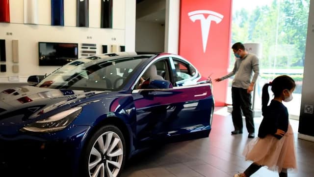People looking at a Tesla car on display at a showroom in Beijing, China, on May 10, 2020. (File photo: AFP)