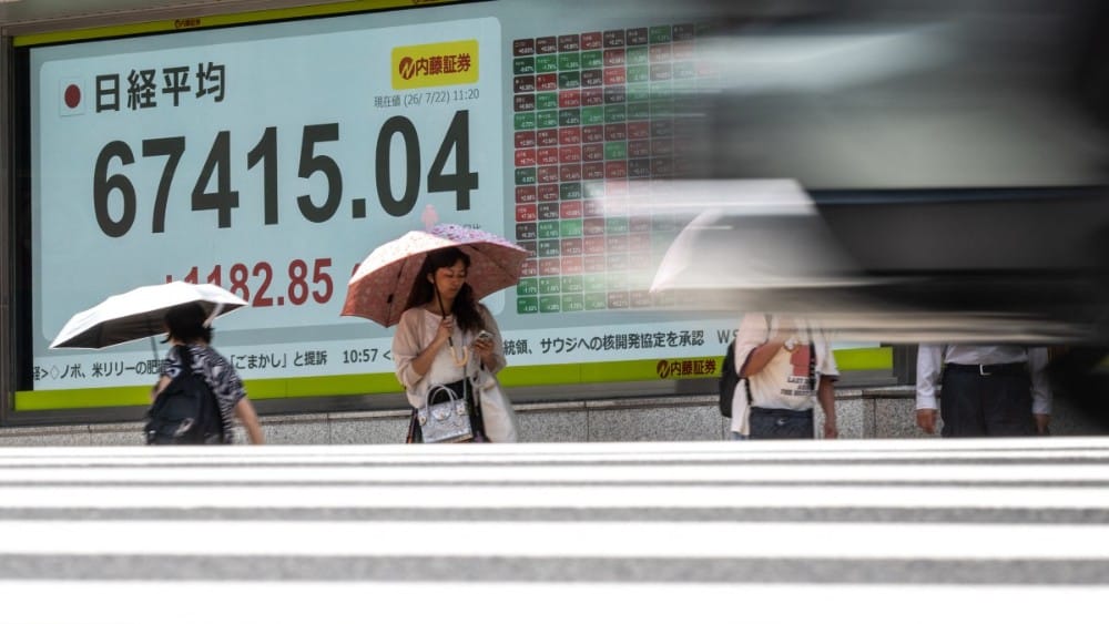 Pedestrians walk past an electronic quotation board displaying the Nikkei Stock Average on the Tokyo Stock Exchange in Tokyo on July 22, 2026. (Photo: AFP)