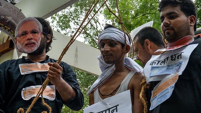 An Indian Youth Congress (IYC) activist acts as a farmer committing suicide during a protest following the completion of two years of the Narendra Modi-led National Democratic Alliance (NDA) in New Delhi. (AFP)