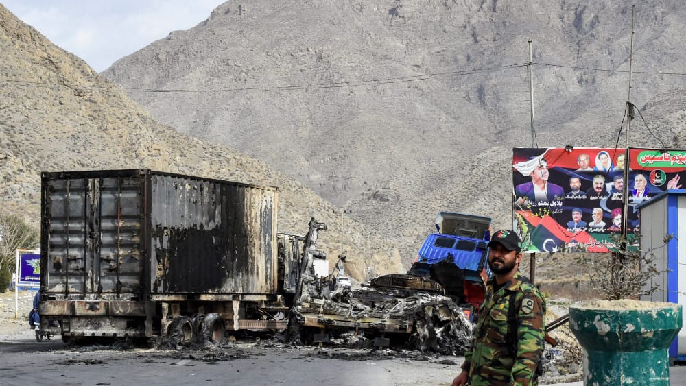 A security personnel stands guard near charred truck containers torched by armed terrorist group Balochistan Liberation Army (BLA) at central Bolan district in Balochistan province on January 30, 2024.