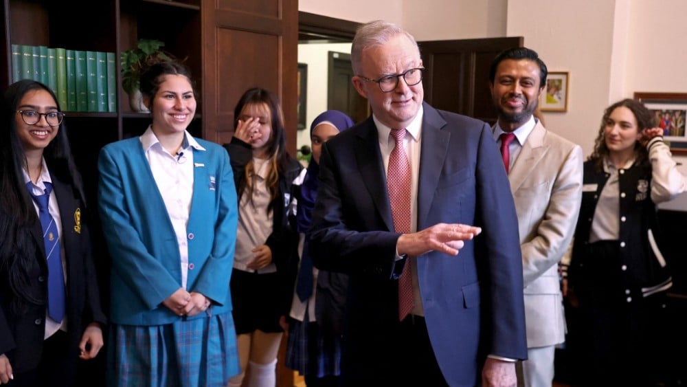 Australia’s Prime Minister Anthony Albanese (C) speaks with students after speaking at an official event at Sydney University in Sydney on July 15, 2026.