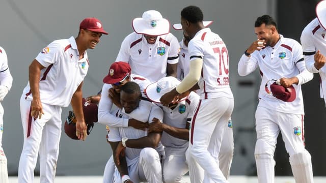 Teammates hug Bowler Jayden Seales (3rd-L) of West Indies after taking the last wicket to defeat Pakistan by 90 runs during the fourth day of the first Test cricket match between West Indies and Pakistan at the Brian Lara Cricket Academy in Tarouba, Trini
