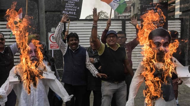 Activists and supporters of India's Congress party shout slogans as they burn effigies of Hardeep Singh Puri (L), Minister of Petroleum and Natural Gas, and Minister of Road Transport Nitin Gadkari during a protest against the government-led ethanol-blend