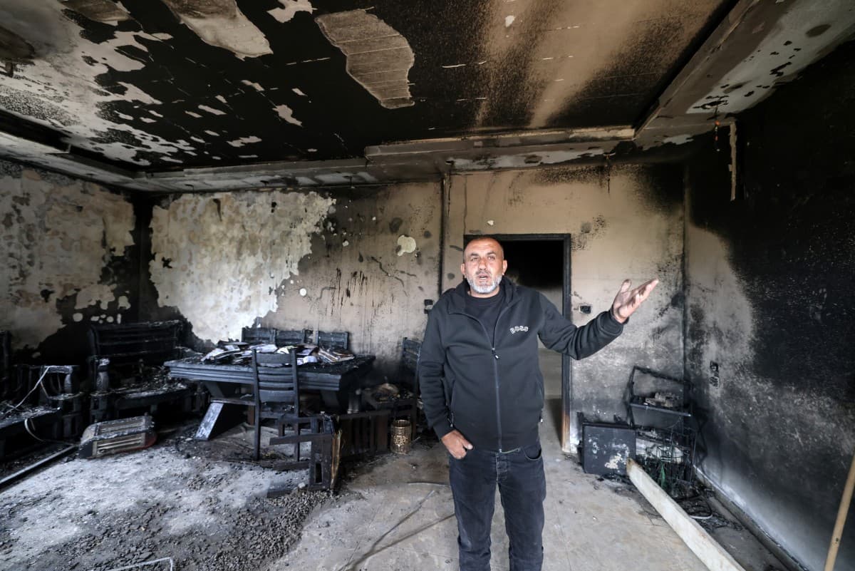 A Palestinian man gestures as he stands in the remains of a burnt-out home following a reported attack by Israeli settlers in the village of Deir al-Hatab, east of the city of Nablus, in the Israeli-occupied West Bank on March 23, 2026 (AFP).