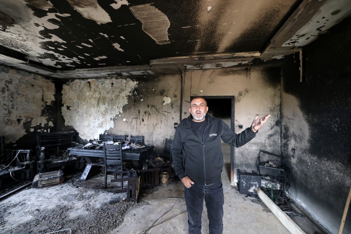 A Palestinian man gestures as he stands in the remains of a burnt-out home following a reported attack by Israeli settlers in the village of Deir al-Hatab, east of the city of Nablus, in the Israeli-occupied West Bank on March 23, 2026 (AFP).