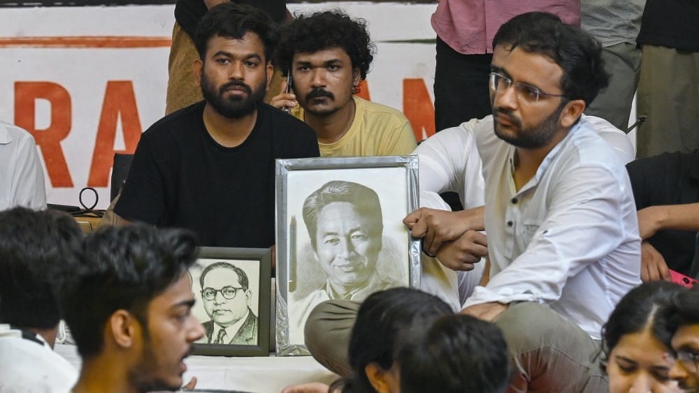 Cockroach Janta Party (CJP) founder Abhijeet Dipke (L) sits on an indefinite hunger strike demanding the resignation of India's Education Minister Dharmendra Pradhan over alleged NEET examination irregularities in New Delhi on July 18, 2026. (AFP)