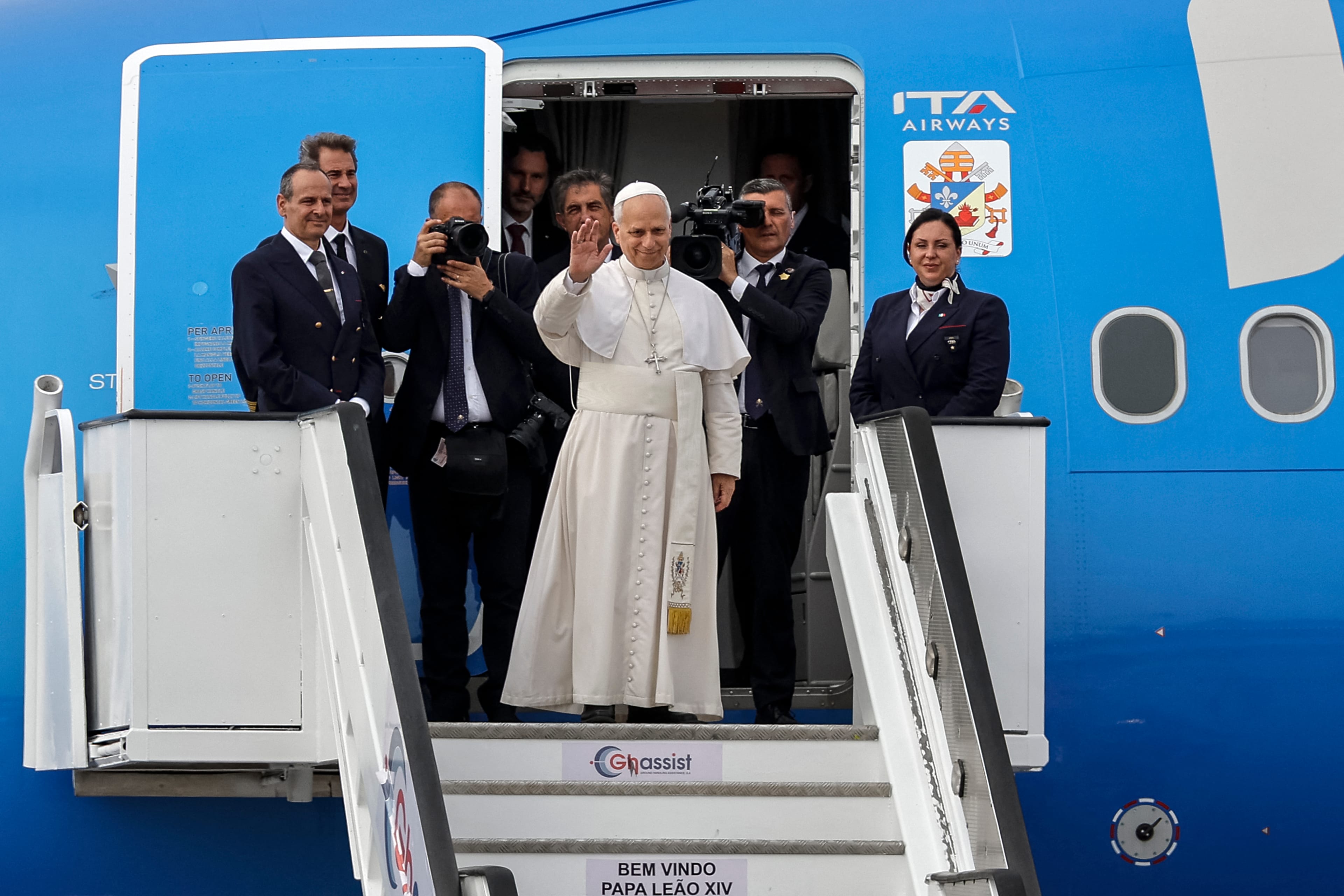 Pope Leo XIV (C) waves as he boards the plane to depart from the "4 de Fevereiro" Luanda International Airport in Luanda on the ninth day of an 11-day apostolic journey to Africa, on April 21, 2026. (AFP)
