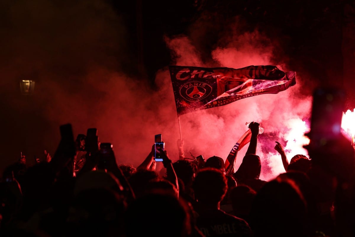 PSG supporters burn flares and wave a flag during gatherings after PSG won the UEFA Champions League final between Paris Saint-Germain (PSG) and Arsenal FC played in Budapest, in Paris on May 30, 2026. (AFP)