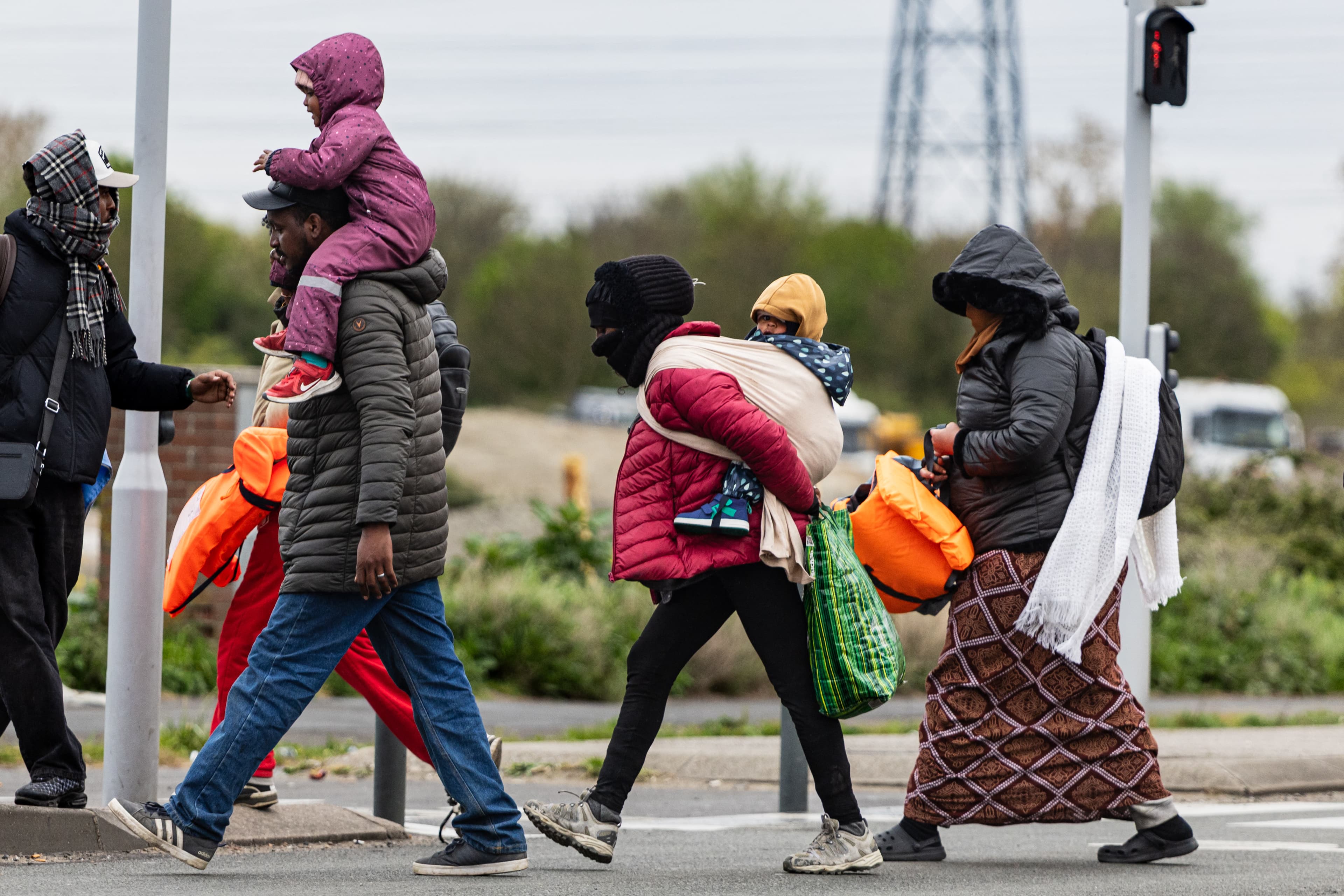 Migrants head to a beach to be smuggled to Britain through the English Channel, in Grande-Synthe, near Dunkirk, northern France on April, 13, 2026. (AFP)