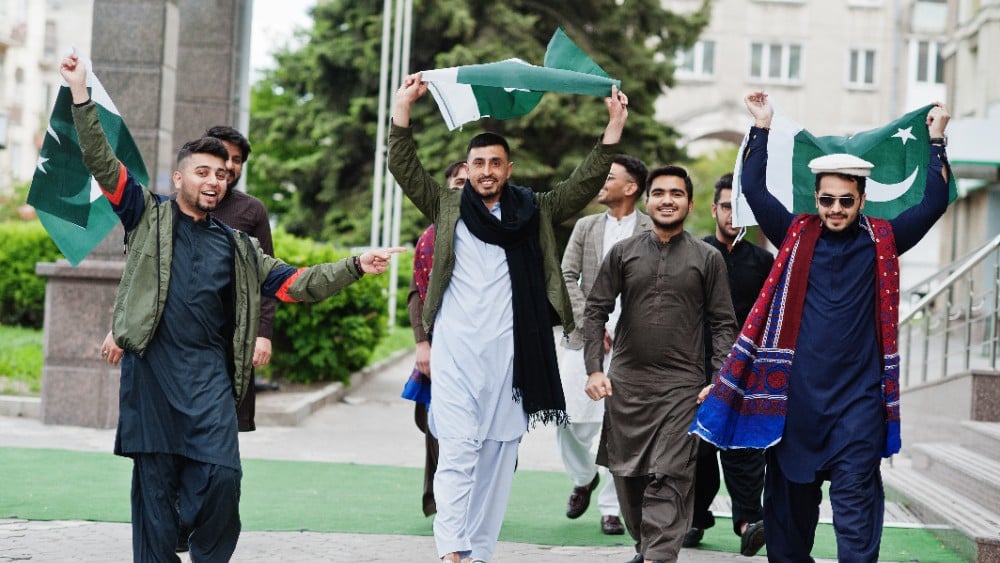 Cheerful Men Celebrate Outdoors with Flags (Photo: Envato)