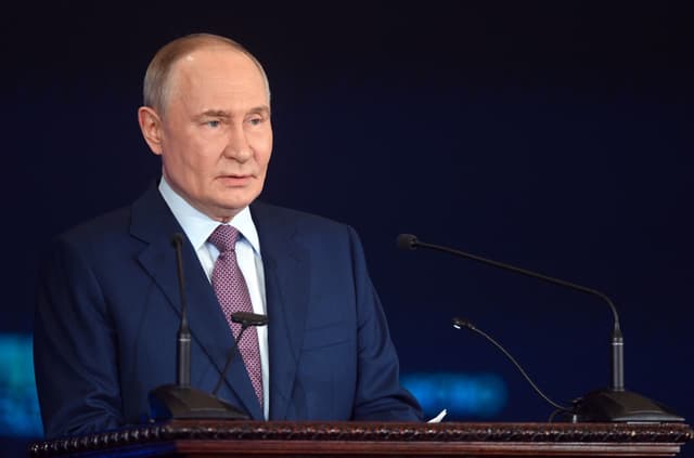 In this pool photograph distributed by the Russian state agency Sputnik, Russia's President Vladimir Putin gives a speech at a meeting of the Russian Geographical Society in Moscow on October 23, 2025. (Photo by Kristina Kormilitsyna / POOL / AFP)