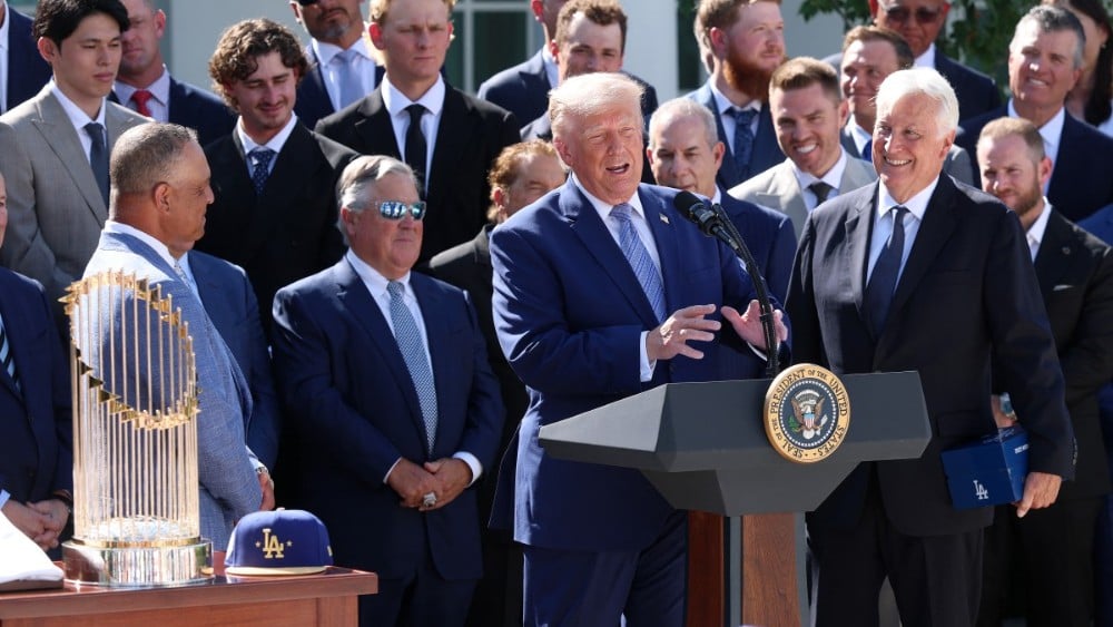 US President Donald Trump (C) delivers remarks alongside Los Angeles Dodgers owner and Chairman Mark Walter (R) as he hosts the 2025 MLB World Series champion Los Angeles Dodgers in the Rose Garden of the White House on July 23, 2026, in Washington, DC. (