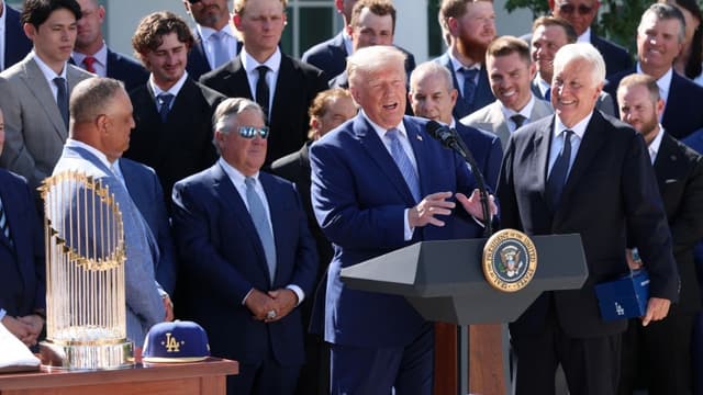 US President Donald Trump (C) delivers remarks alongside Los Angeles Dodgers owner and Chairman Mark Walter (R) as he hosts the 2025 MLB World Series champion Los Angeles Dodgers in the Rose Garden of the White House on July 23, 2026, in Washington, DC. (