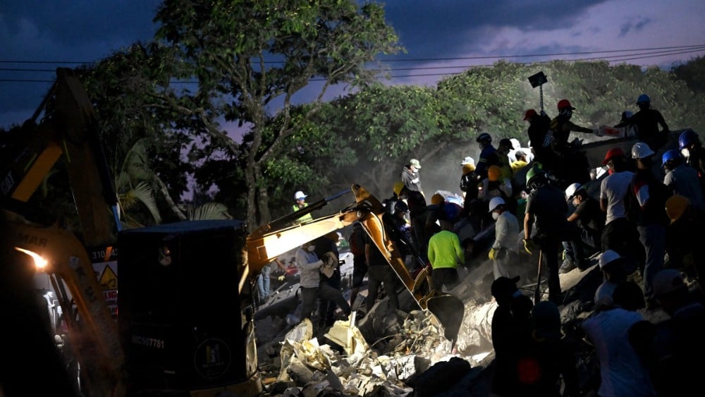 Rescuers and volunteers search for survivors amid the rubble of a collapsed building after an earthquake in Cali, Colombia on August 11, 2026. (Photo: AFP)