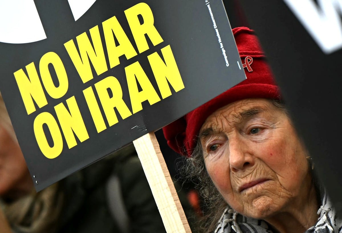 People hold placards during a protest against the US-Israeli attacks on Iran, in Parliament Square in central London, on February 28, 2026. (AFP)