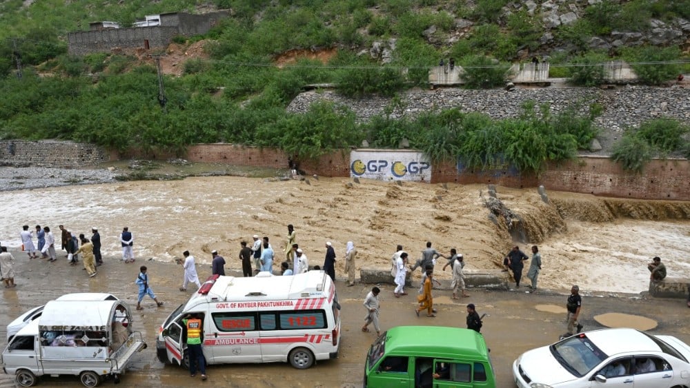 Commuters wait as floodwater swamps a road following heavy monsoon rains at Landi Kotal in Pakistan's Khyber Pakhtunkhwa province on July 20, 2026. (Photo by Abdul MAJEED / AFP)