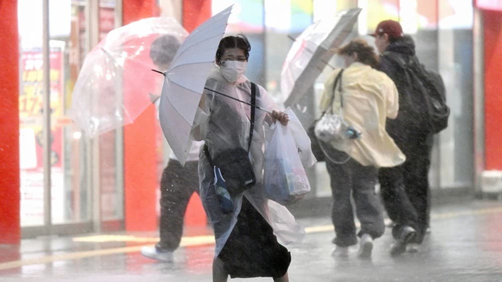 A pedestrian holds on to her umbrella amid strong winds and heavy rainfall in Chiba on September 21, 2026. (Photo: AFP)