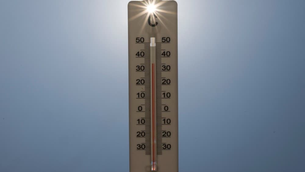 This photograph shows sun rays shining through a handheld house thermometer reading 35 degrees Celsius, in Montreuil on the afternoon of August 14, 2025, amid a heatwave in Europe.