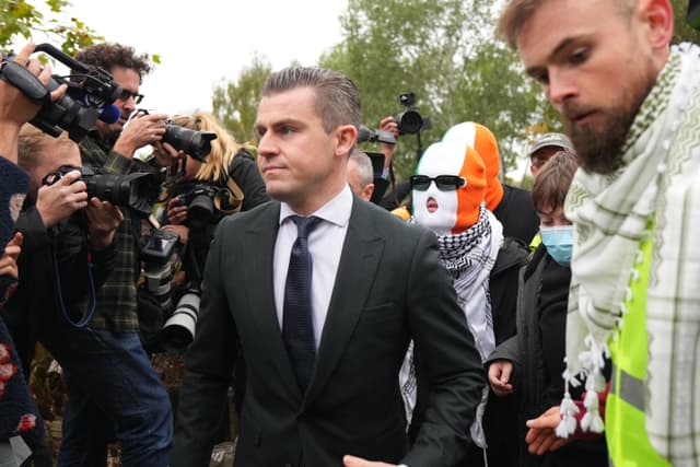 person believed to be Liam Óg Ó hAnnaidh, aka Mo Chara, in a mask, a member of the Irish language band Kneecap, arrives at Woolwich Crown Court in London, Friday