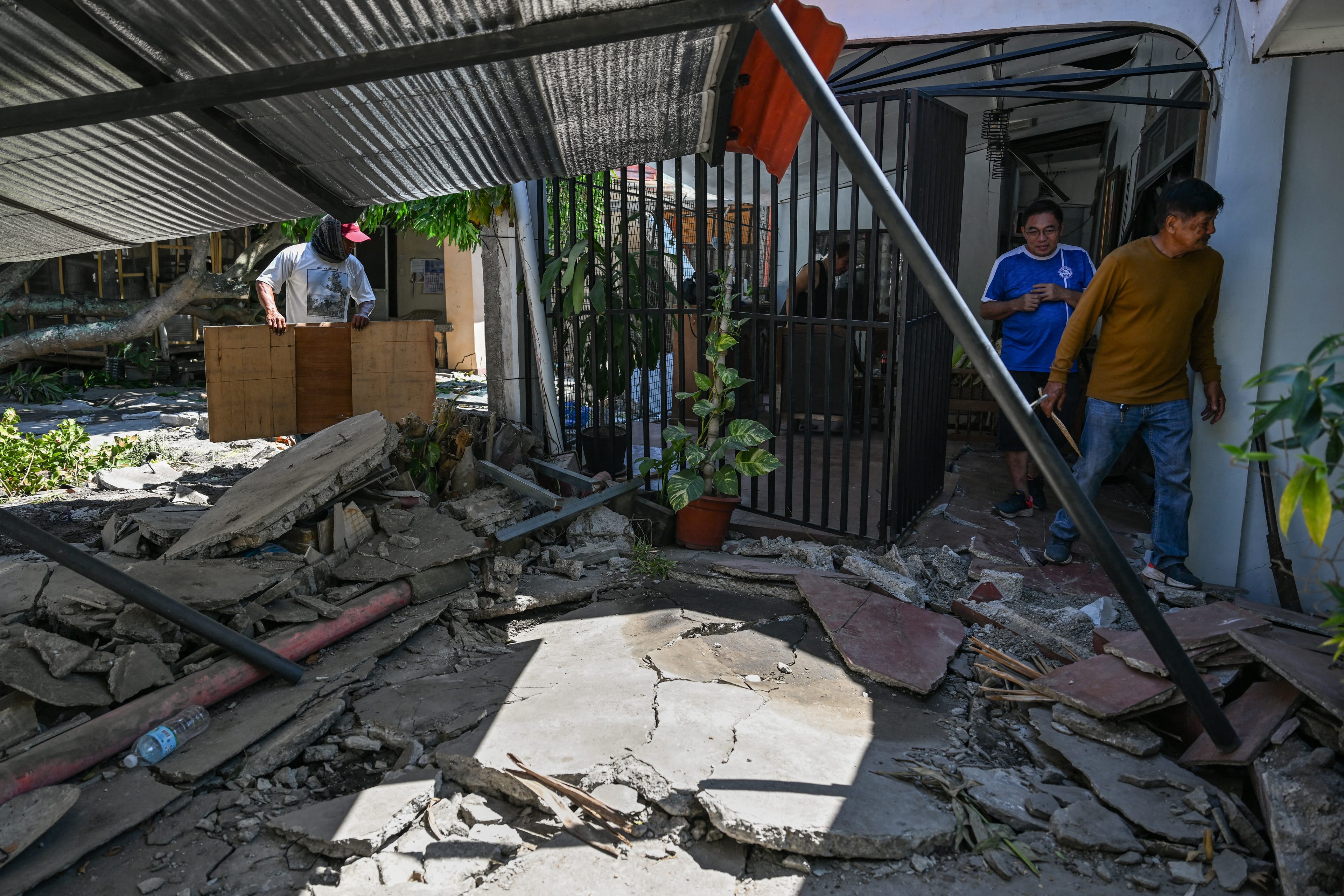 People clean up their damaged house after a 7.8 magnitude earthquake in General Santos City on June 9, 2026. (Photo: AFP)