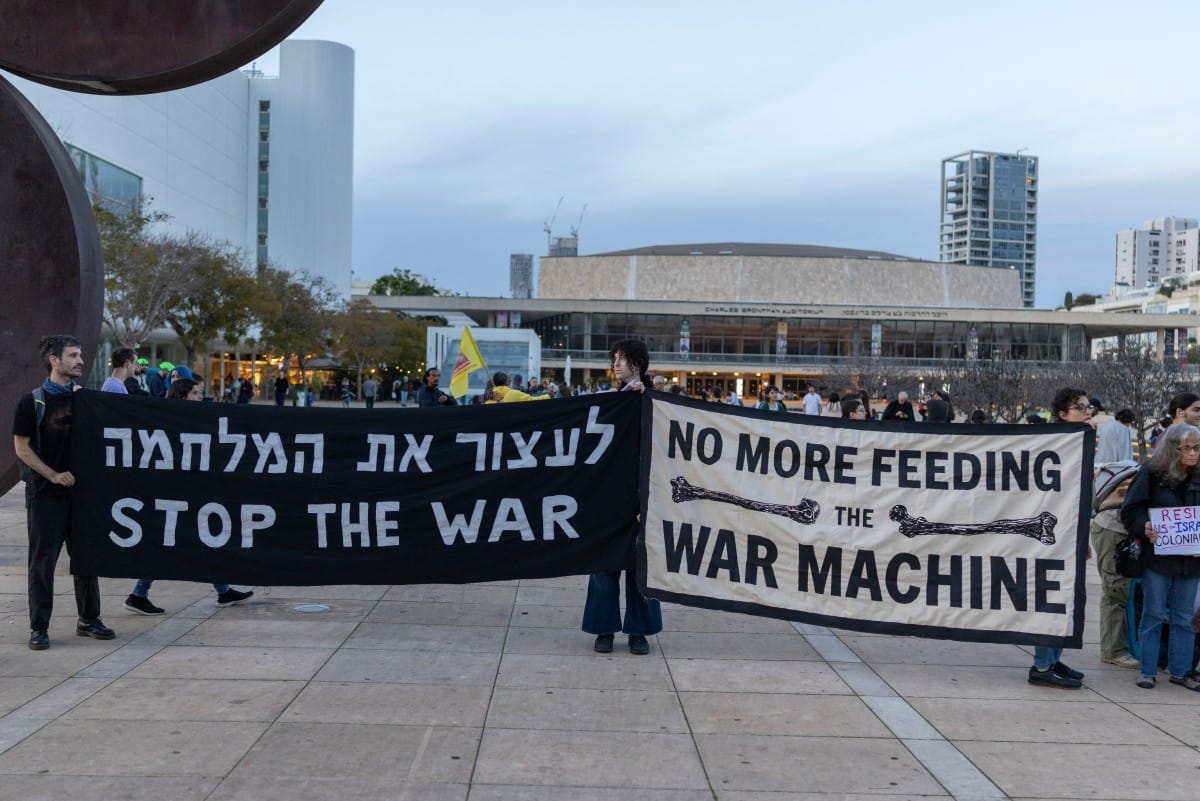 Demonstrators hold banners while gathering for the weekly anti-war protest at HaBima Square in Tel Aviv on March 28, 2026. (AFP)