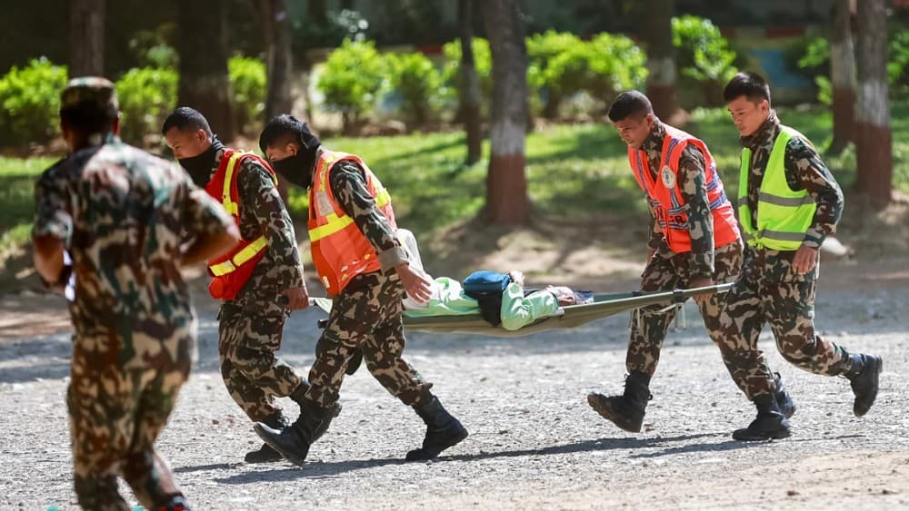 Army personnel carry a rescued resident at an army camp following flash floods, in Battar Bazar town of Nepal's Nuwakot district on August 28, 2026. (Photo: AFP)