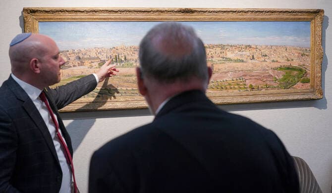 US Ambassador to Israel Mike Huckabee (R) is shown a painting of Jerusalem during a visit to the Beit Hanassi presidential residence, in Jerusalem, on September 15, 2025.