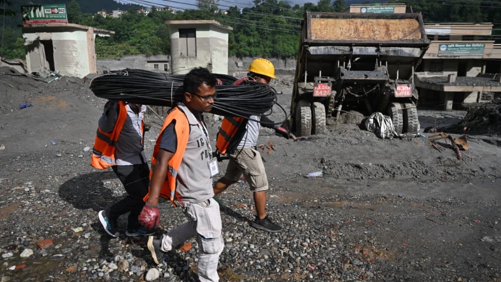 Rescue workers carry cabling at Trishuli Center in Nepal's Nuwakot district on August 30, 2026, after catastrophic flooding on the Nepal-Tibet border. (AFP)