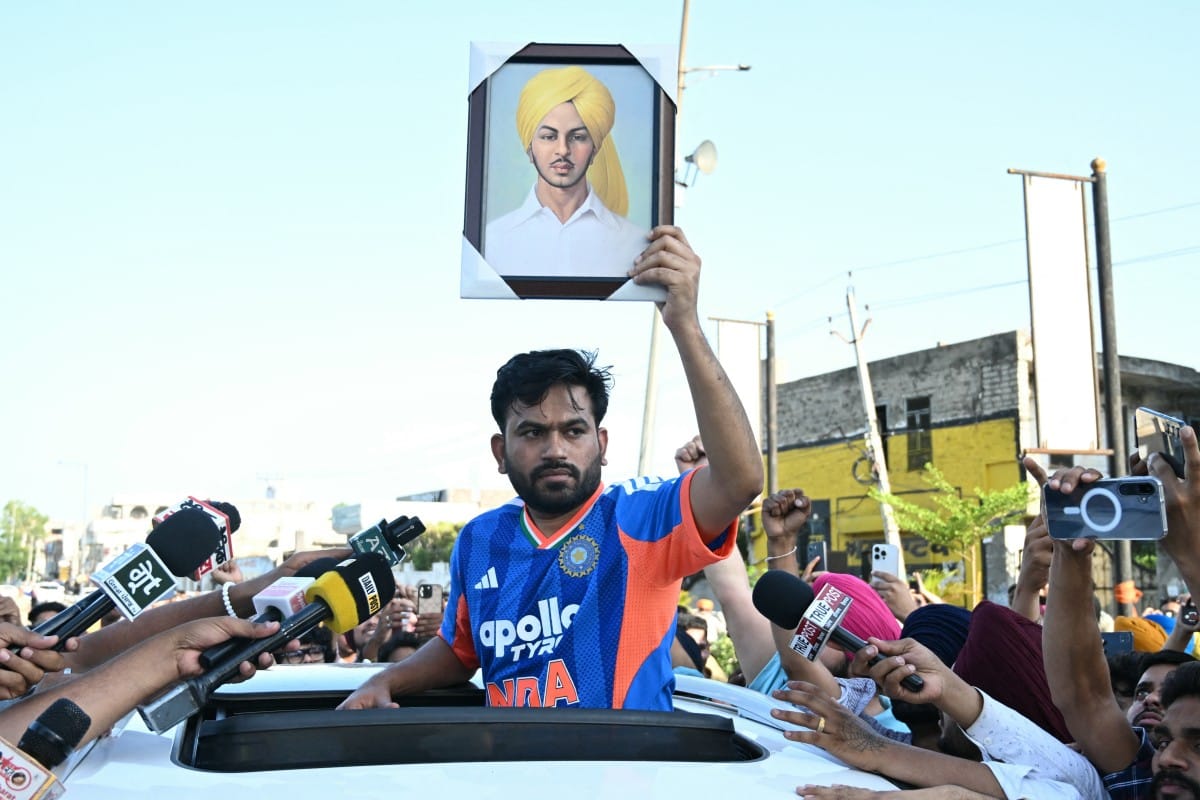 Cockroach Janta Party (CJP) founder Abhijeet Dipke (C) holds a portrait of Shaheed Bhagat Singh while he protests over alleged irregularities in the country's major examinations, in Amritsar on June 13, 2026. (Photo by Narinder NANU / AFP)