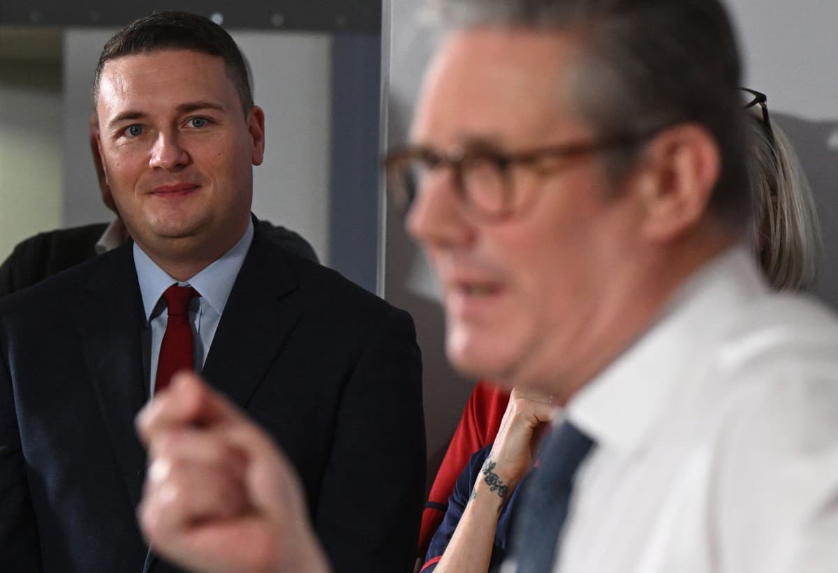 Britain's Health Secretary Wes Streeting (L) listens as Britain's Prime Minister Keir Starmer delivers a speech on a plan to reduce NHS waiting times, during a visit to the South West London Elective Orthopaedic Centre (SWLEOC) in Epsom, south-west of Lon