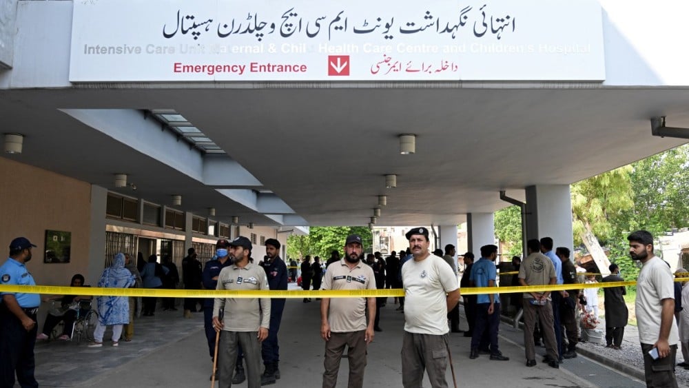 Security personnel stand guard following a fire incident outside the Mother and Child Health (MCH) ward at the Pakistan Institute of Medical Sciences (PIMS) Hospital in Islamabad on August 26, 2026. (Photo: AFP)