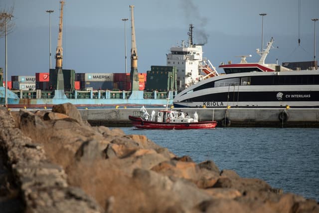 An ambulance boat carrying crew members wearing hazmat suits, returns to the port of Praia, the capital of Cape Verde, on May 5, 2026 after a visit to the cruise ship MV Hondius, while stationary off the harbor. (AFP)