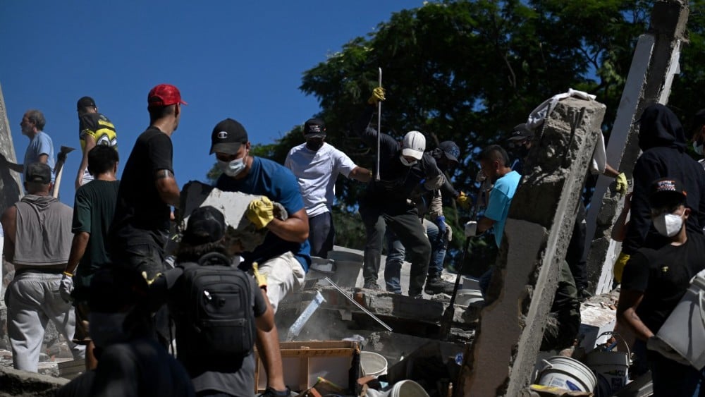 People and rescuers look for survivors amid the rubble of a collapsed building after an earthquake in Cali, Colombia, on August 10, 2026. (Photo: AFP)