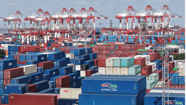An aerial view shows stacked containers at the Shanghai Port container terminal in Shanghai on December 8, 2025. (Photo by AFP/File)