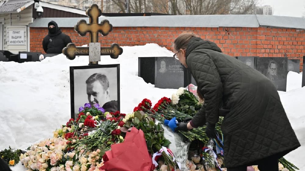 A woman lays flowers at the grave of Russian opposition leader Alexei Navalny at the Borisovo cemetery in Moscow on February 16, 2026, marking the second anniversary of his death in an Arctic colony. (Photo: AFP)