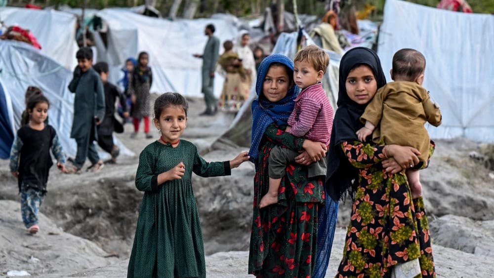 Afghan internally displaced children stand near temporary tents along a river in the Marawara district of Kunar province on April 12, 2026. (AFP)