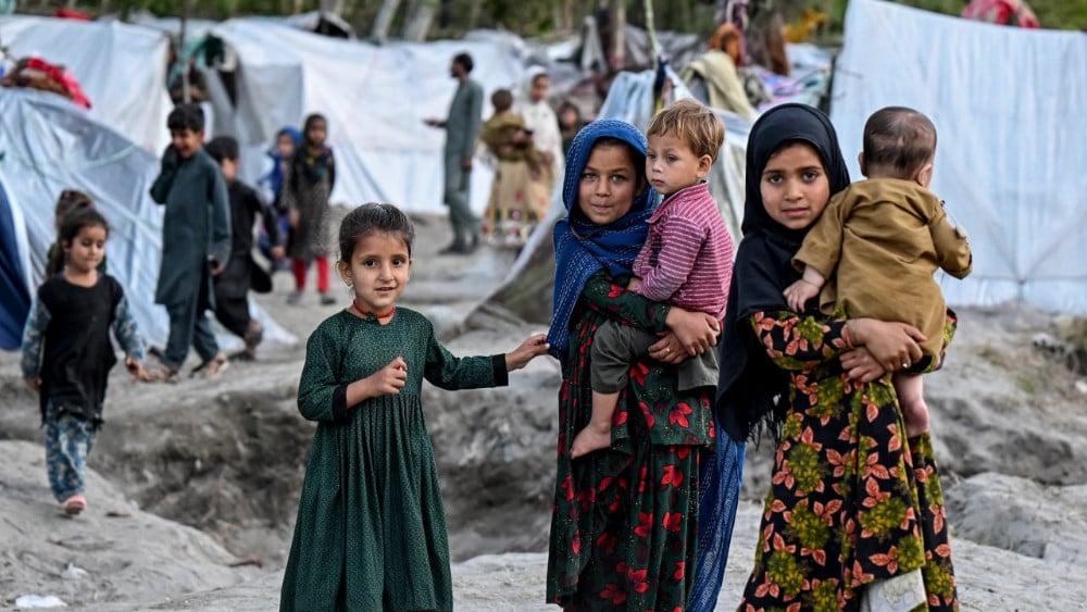 Afghan internally displaced children stand near temporary tents along a river in the Marawara district of Kunar province on April 12, 2026. (AFP)