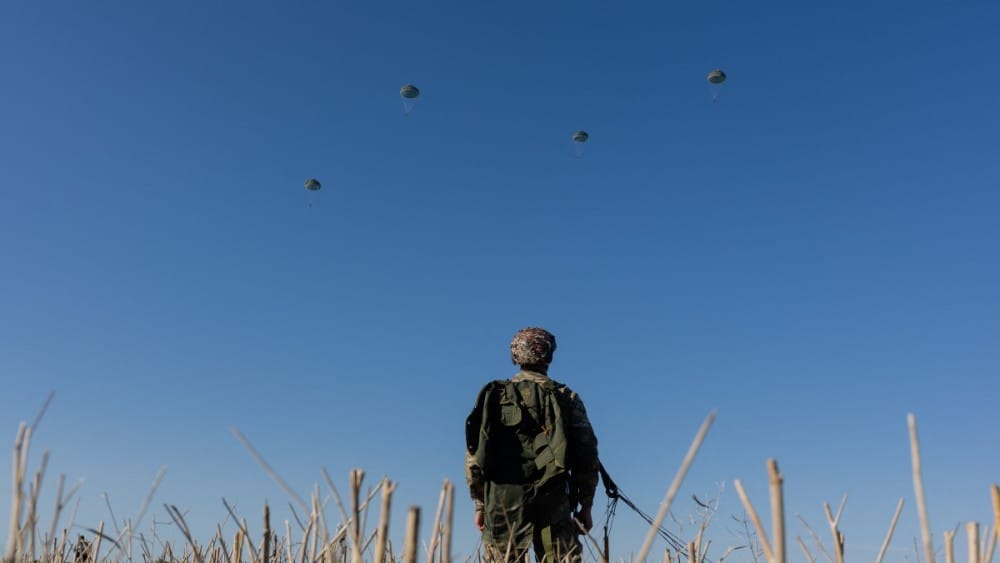 A Ukrainian serviceman of the Air Assault Forces watches the parachutists land during parachute jump training in an undisclosed location on August 12, 2026, amid the Russian invasion of Ukraine. (Photo: AFP)